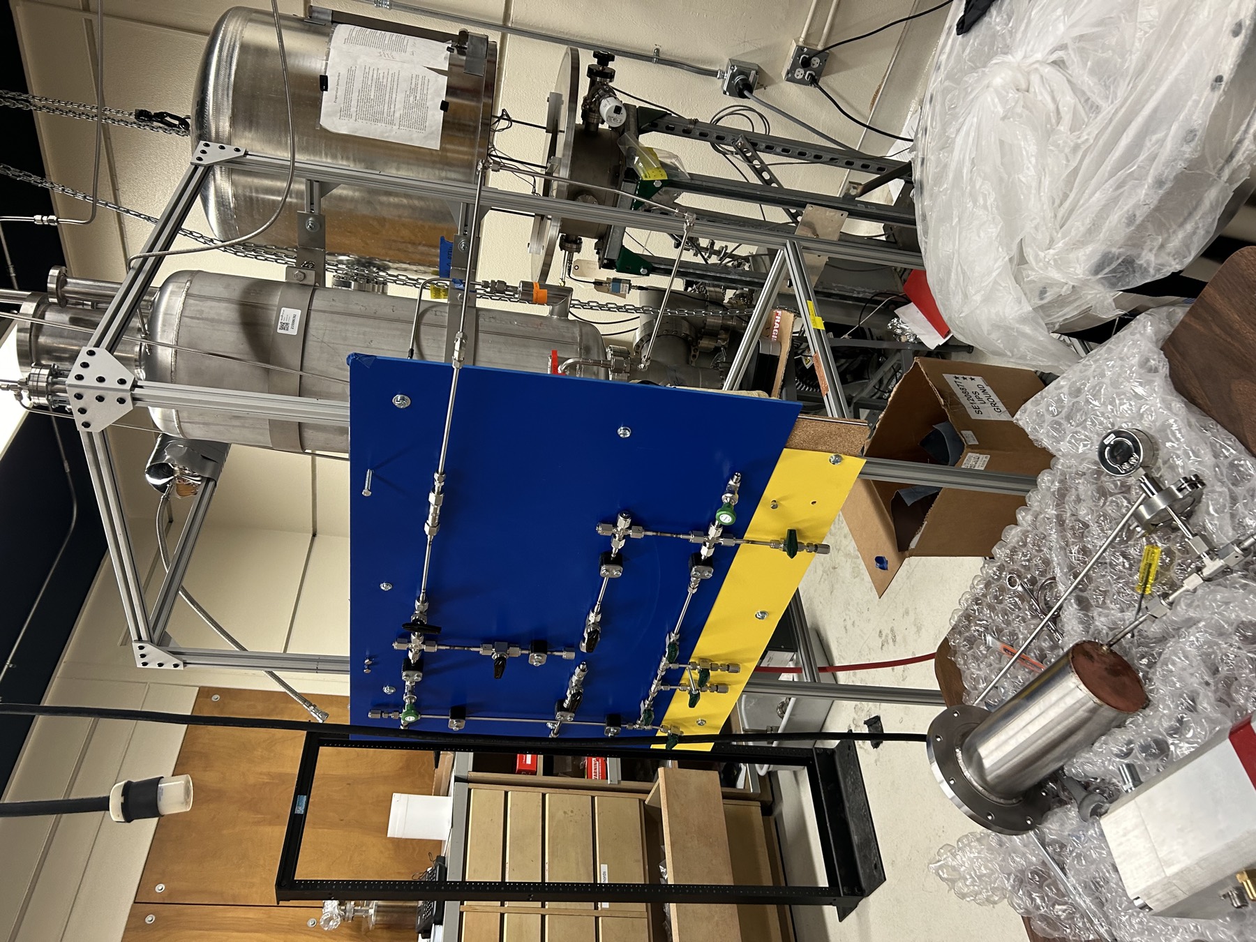 The liquid argon condenser under assembly: steel tanks in a t-slot frame with a blue valve panel